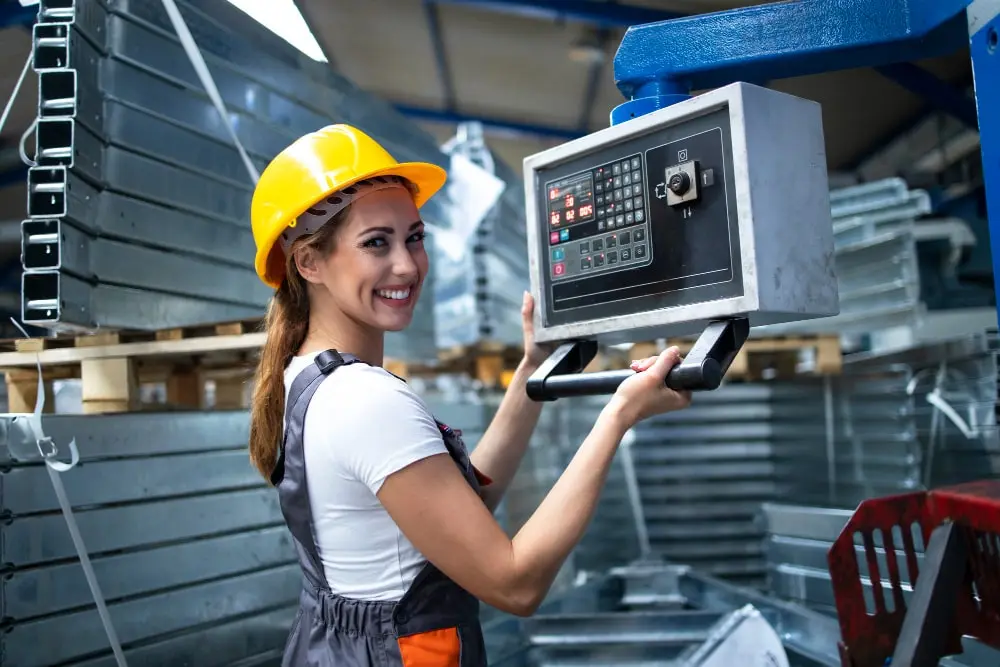 A female industrial worker operating a control panel in a modern factory environment, showcasing the use of Advanced Industrial Automation Systems.